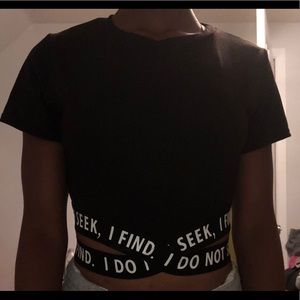 Black crop top with straps around waist.